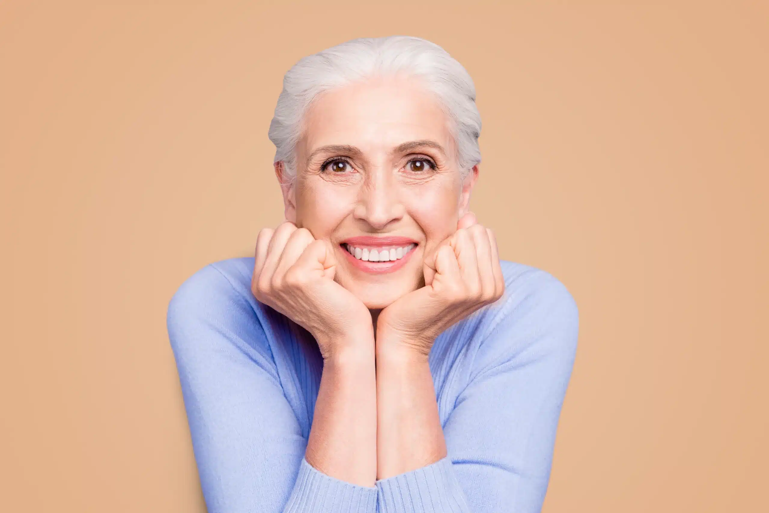 A confident woman smiling naturally after advanced cosmetic dental treatment with veneers and Invisalign